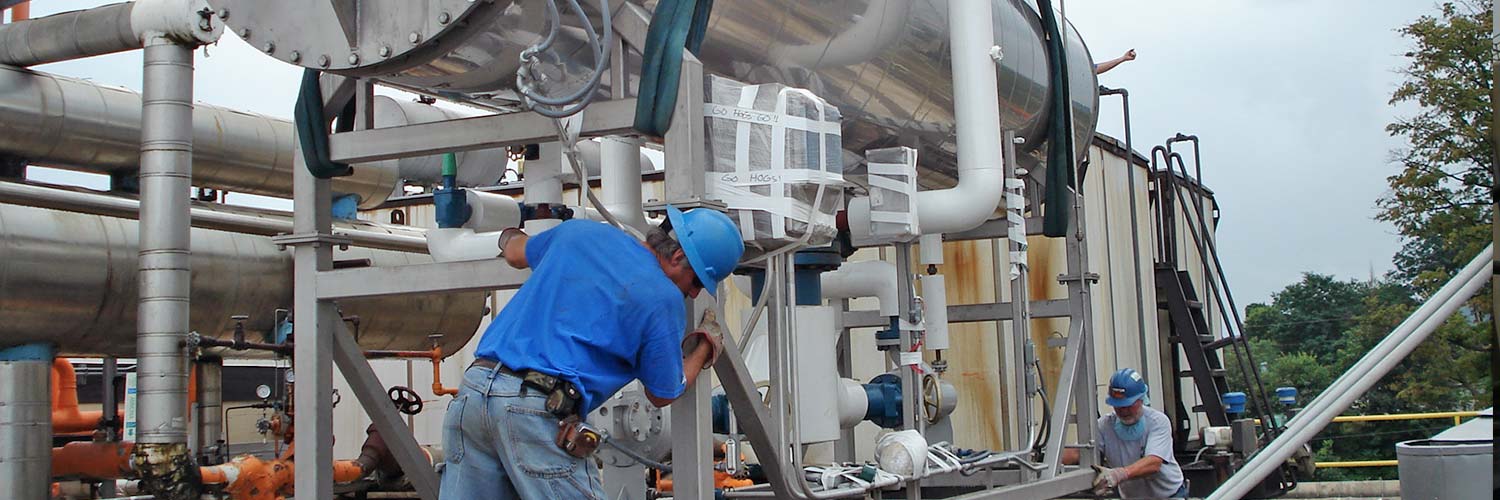 Refrigeration engineers working on refrigeration unit